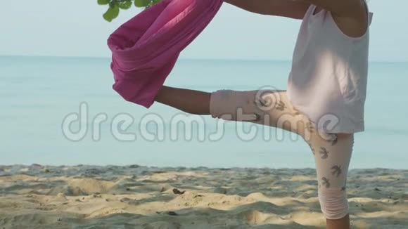 小可爱的女孩做瑜伽在海滩上吊床视频的预览图