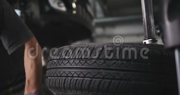 专业的汽车维修人员在汽车维修服务延时内更换车轮上的轮胎下一个机械平衡轮视频的预览图