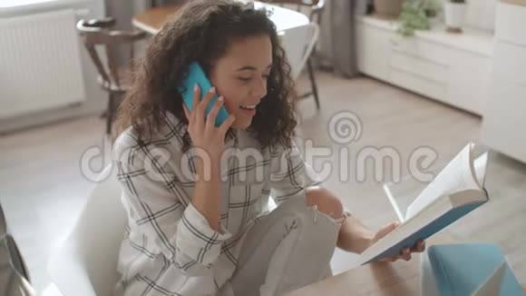 年轻漂亮的女人在可爱的家里用手机说话视频的预览图