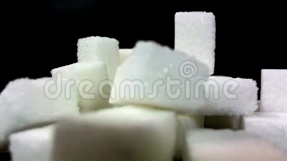 糖被灌在一堆糖块上在黑色背景下视频的预览图