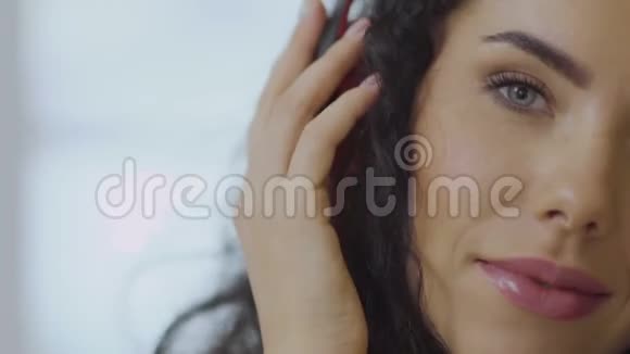 卷发的黑发女人喜欢用耳机听音乐视频的预览图