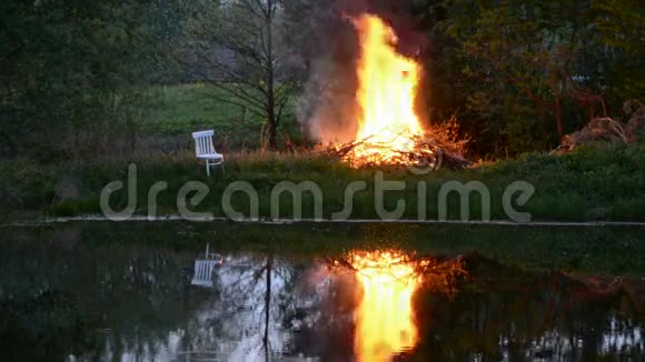 春天傍晚池塘附近的农场失火视频的预览图