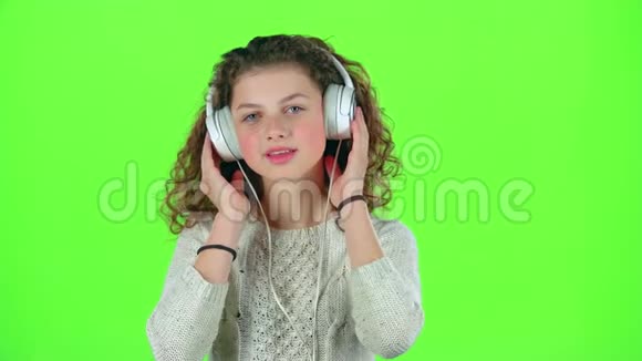 孩子听耳机里的音乐绿色屏幕视频的预览图