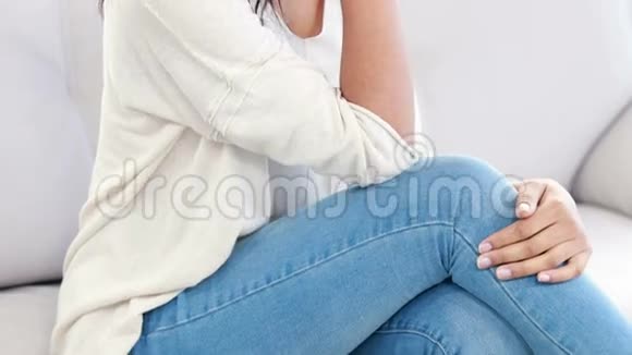 穿着衣服的女人抱着头躺在沙发上视频的预览图