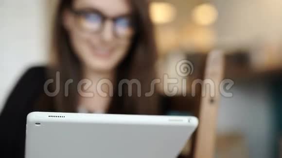 女人坐在餐馆的桌子旁带着可以上网的平板电脑视频的预览图