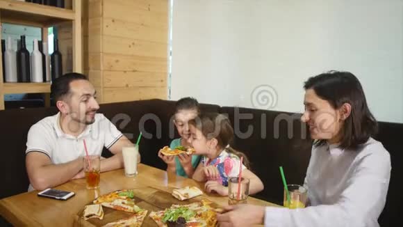 一家四口在咖啡馆里一起吃披萨视频的预览图