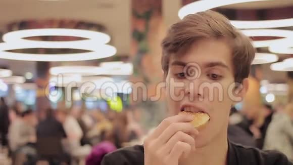 年轻人在购物中心的食物场吃汉堡包肖像视频的预览图