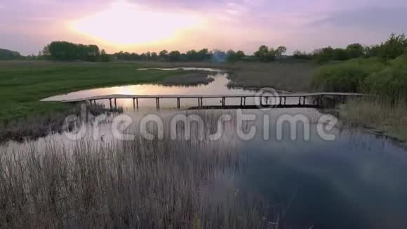 骑自行车的人骑在河对岸的木桥上视频的预览图