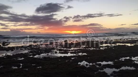 太平洋上空的日落从夏威夷考艾岛的基卡哈黑沙滩的黑沙滩上看地平线上的尼豪岛视频的预览图