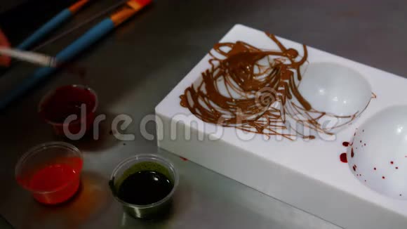 工人用彩色巧克力画巧克力模具视频的预览图