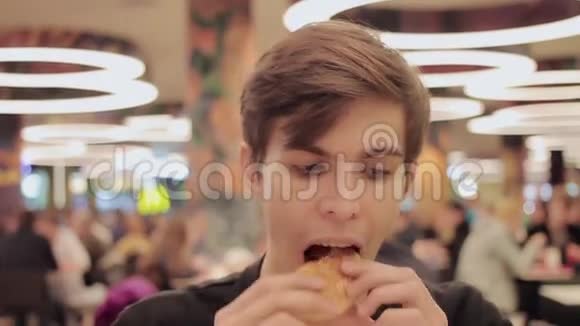 年轻人在购物中心的食物场吃汉堡包肖像视频的预览图