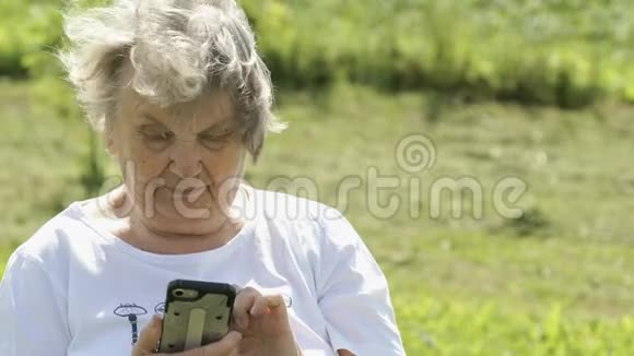 成年老年妇女在户外手持手机视频的预览图