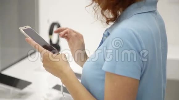 女人在商店里选择智能手机视频的预览图