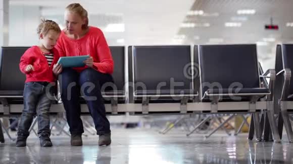 年轻的母子在机场候机楼视频的预览图