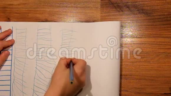 近距离观看儿童手在纸上的绘画用蓝色铅笔画梯子视频的预览图
