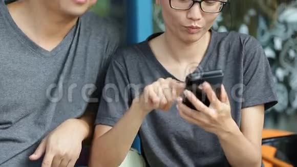 快乐的亚洲男人和女朋友一起用手机视频的预览图