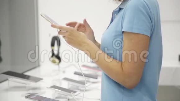 女人在商店里选择智能手机视频的预览图