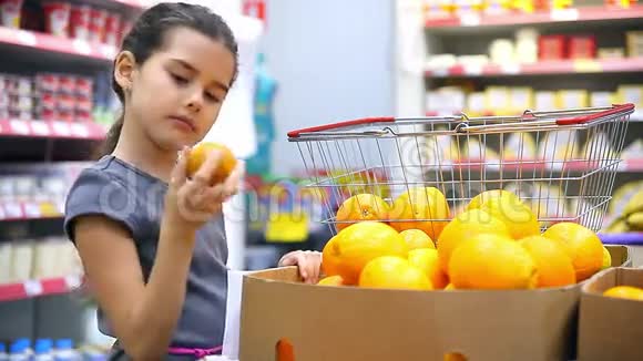 在超市买橘子水果的女孩视频的预览图