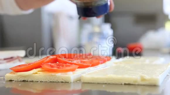 手准备奶酪和番茄三明治视频的预览图