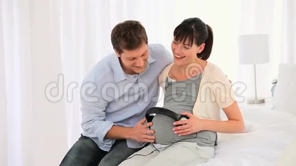 一对夫妇让他们未来的孩子听音乐视频的预览图
