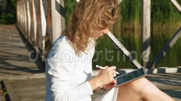 女人在户外使用电脑平板电脑视频的预览图