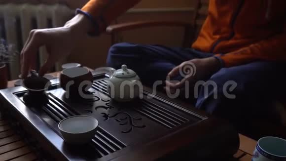 在中国传统的茶道上人们正在茶壶里倒茶一套茶饮设备视频的预览图