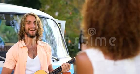 女人在拍一个弹吉他的男人的照片视频的预览图