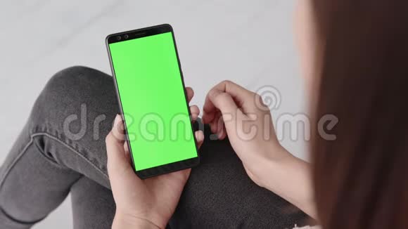 家中年轻女性移动智能手机的绿色屏幕显示色度键视频的预览图