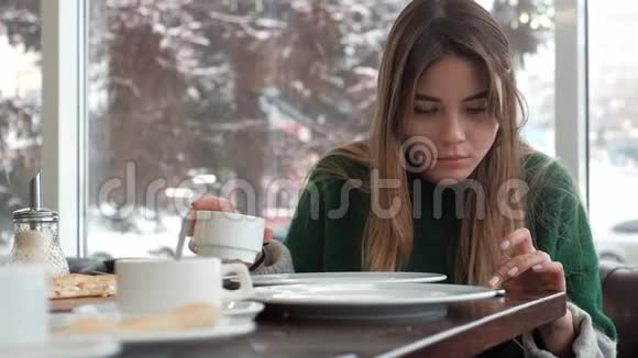 女人发短信在咖啡馆的智能手机上发短信视频的预览图
