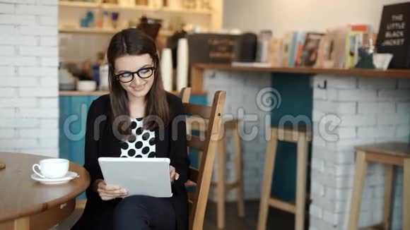女人坐在餐馆的桌子旁带着可以上网的平板电脑视频的预览图