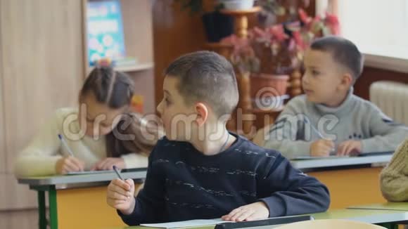孩子们坐在书桌前写字视频的预览图