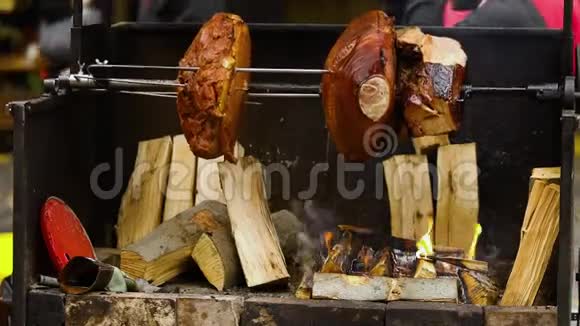 大块美味的猪肉火腿在明火上煮熟街头美食户外食品露营和烹饪视频的预览图