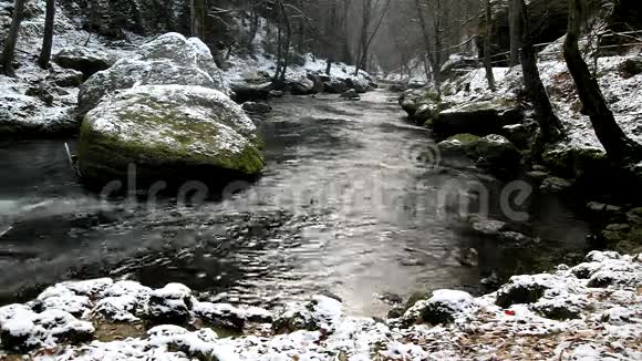 小溪清澈的水中有一大块巨石冬天开始了视频的预览图