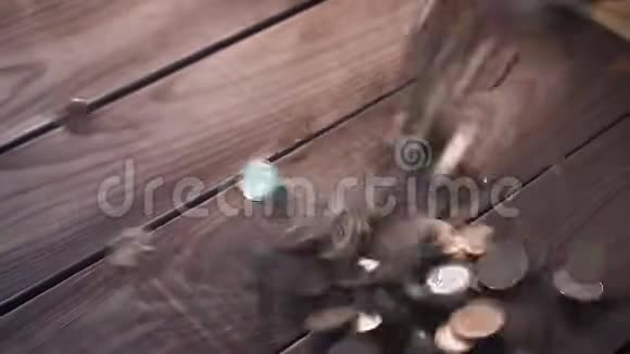 一堆硬币落在木桌上视频的预览图