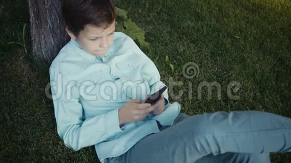 青少年在户外的智能手机上玩电子游戏视频的预览图