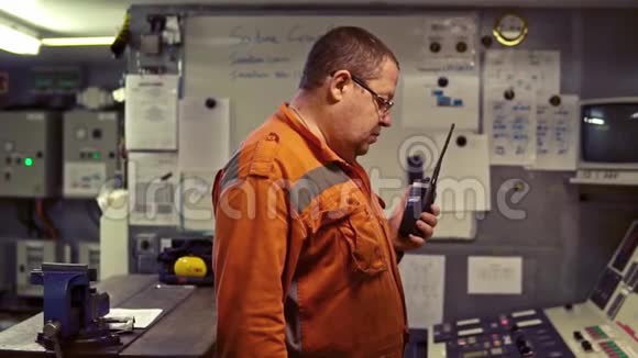 轮机工程师在发动机控制室进行无线电通讯视频的预览图