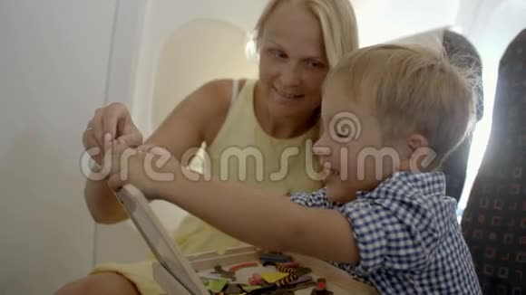 妈妈和儿子在飞机上玩游戏视频的预览图