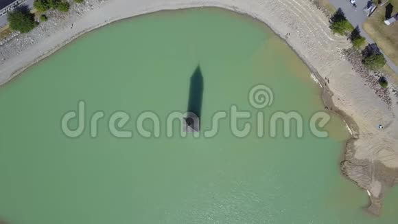 意大利库伦从雷西亚湖水中升起的村庄旧钟楼的无人机航景图视频的预览图