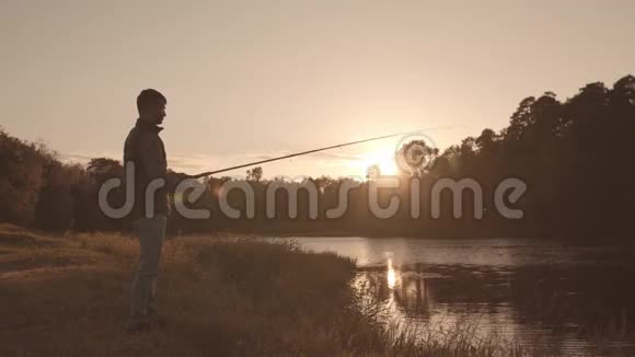 渔夫拿着纺棒在河上钓鱼一个周末的渔夫爱好休闲活跃的夏天和视频的预览图
