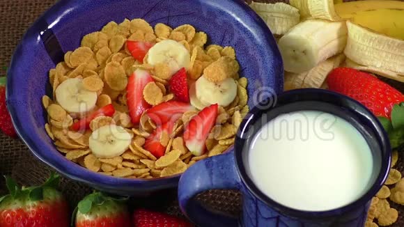 健康的早餐玉米片新鲜草莓香蕉和牛奶视频的预览图