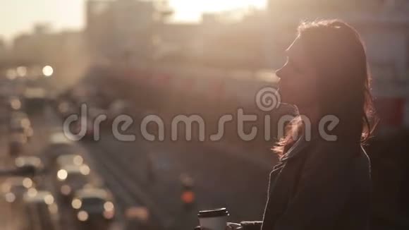 美丽的女人在城市桥上喝咖啡视频的预览图