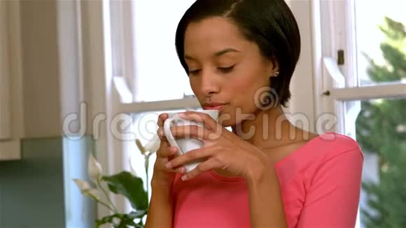 漂亮的女人喝着白色的杯子视频的预览图