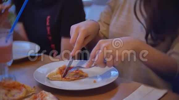 一家群孩子在室内的咖啡馆里吃披萨青少年在咖啡馆慢动作吃快餐视频的预览图