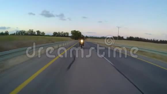 一辆摩托车在弯曲的道路上行驶视频的预览图