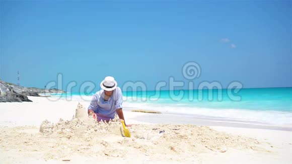 年轻的父亲和小孩在热带海滩上做沙堡视频的预览图