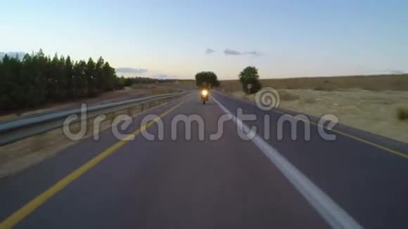 一辆摩托车在弯曲的道路上行驶视频的预览图