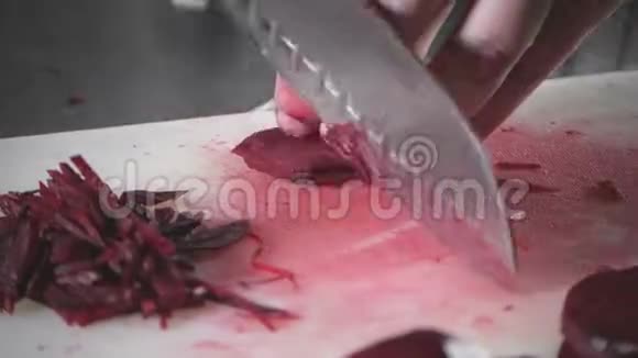 用刀切新鲜蔬菜的手特写年轻厨师在一个白色的切割板特写上切割甜菜烹饪视频的预览图