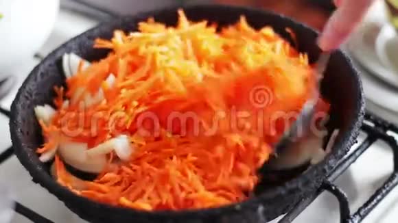洋葱和胡萝卜在旧的煎锅里炒视频的预览图