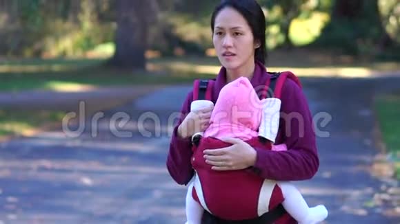 亚洲母亲和婴儿在公园户外的慢动作视频的预览图