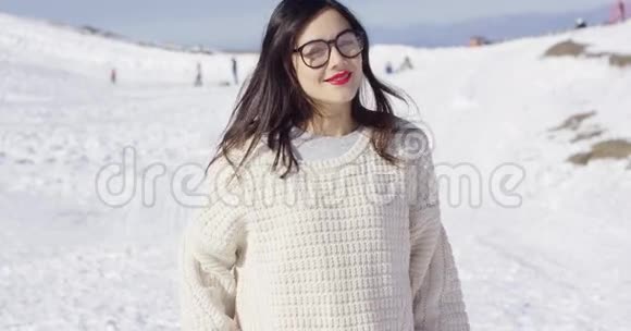 滑雪坡上穿毛衣的年轻微笑女子视频的预览图